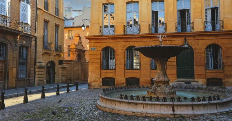 Façade majestueuse de l'Hôtel de Caumont et sa cour d'honneur à Aix-en-Provence sous un ciel ensoleillé